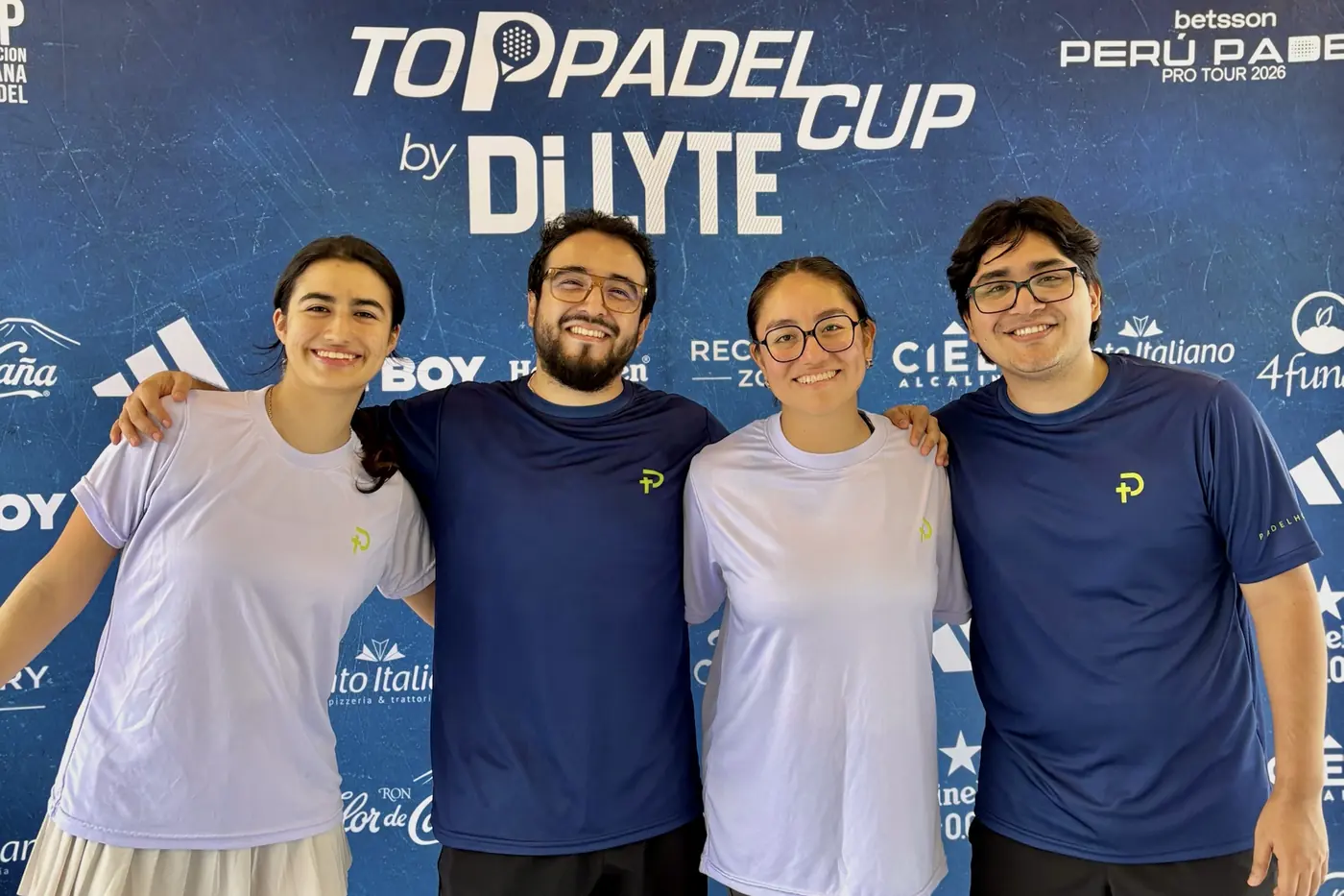 Cuatro jugadores de la comunidad Padelhood posando frente al backdrop del Top Padel Cup