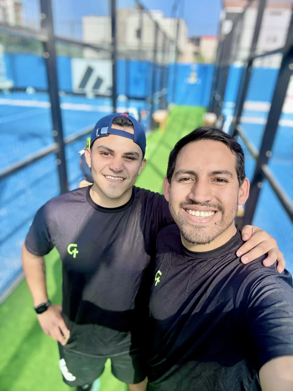Selfie de dos amigos en una cancha de pádel
